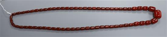 A single strand simulated cherry amber barrel shaped bead necklace, gross weight 84 grams, 96 cm.